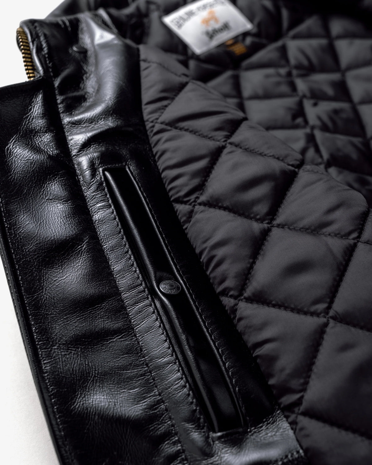 Shot of interior pocket and black quilted lining on black horsehide leather jacket. See product details for more information.