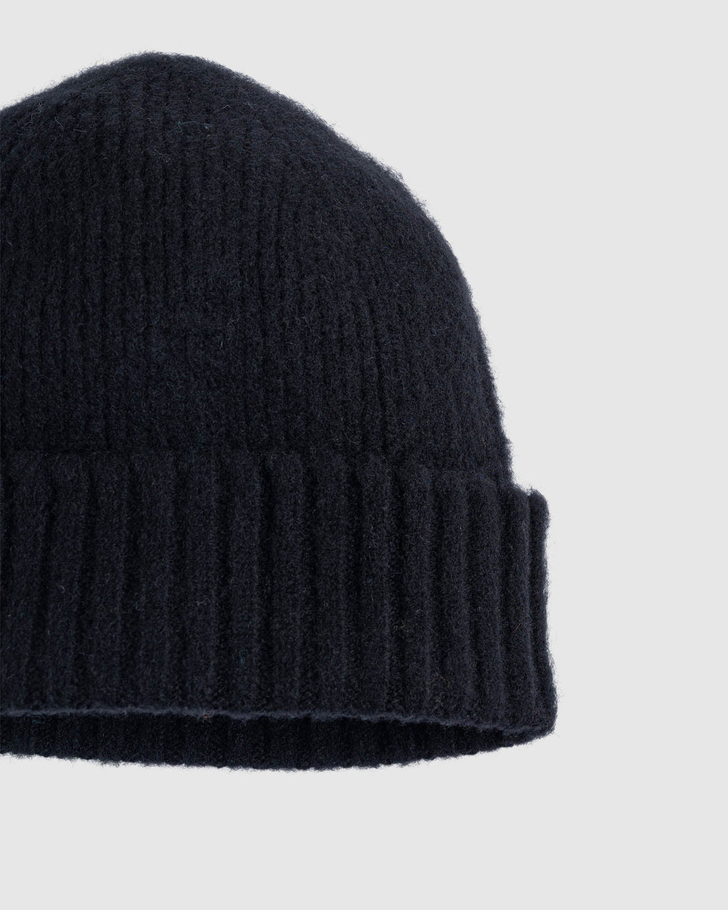 Slightly closer shot of classic wool beanie, black color, showing some of the merino wool texture. See product details for more information.